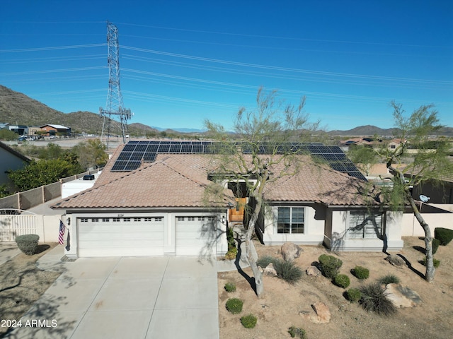 view of front of house featuring a mountain view, a garage, and solar panels