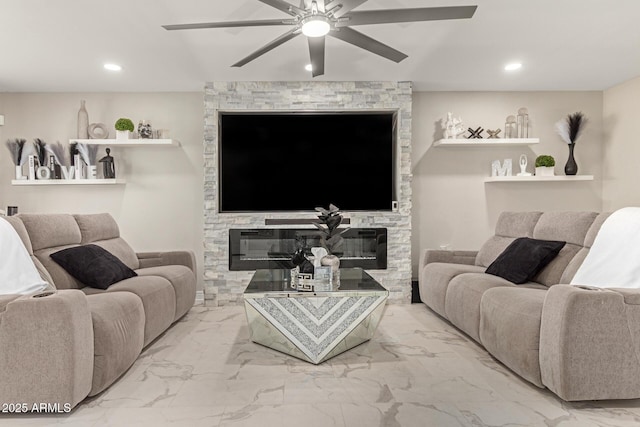 living room featuring ceiling fan and a stone fireplace