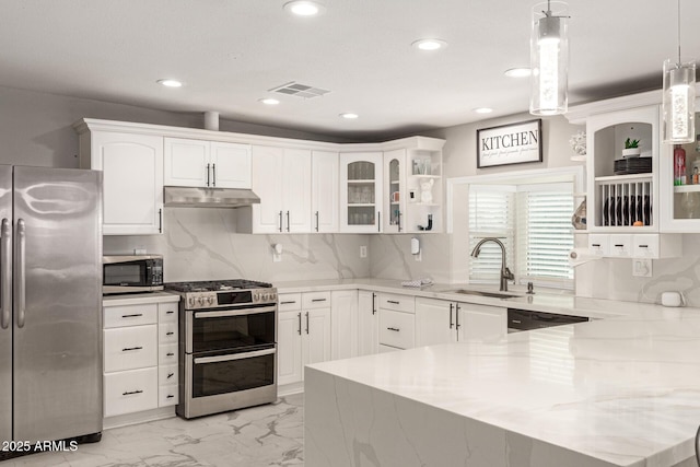 kitchen featuring white cabinetry, hanging light fixtures, decorative backsplash, sink, and stainless steel appliances