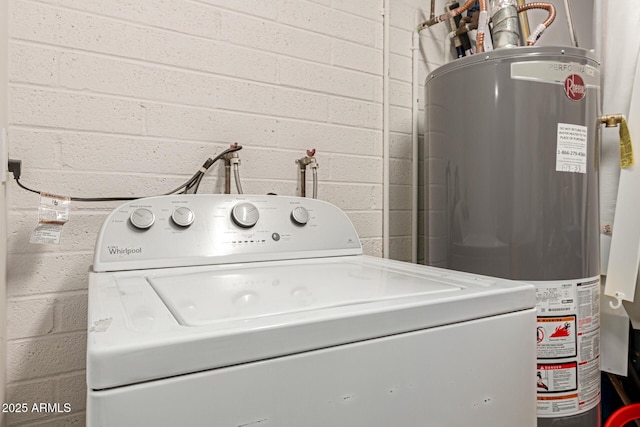 washroom with gas water heater, brick wall, and washer / dryer