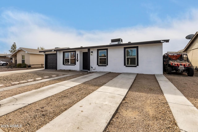 single story home with a garage and central AC unit