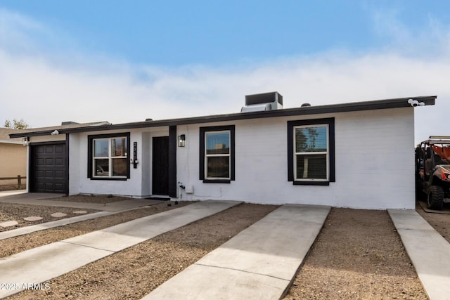 ranch-style house with a garage and central AC unit