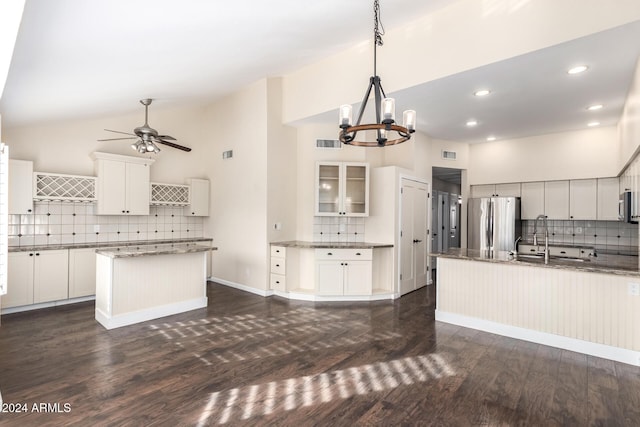 kitchen featuring stainless steel appliances, white cabinets, high vaulted ceiling, decorative light fixtures, and a kitchen island