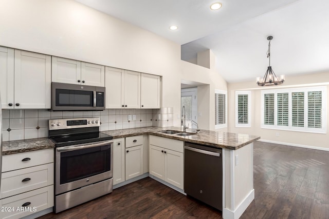 kitchen with sink, vaulted ceiling, tasteful backsplash, decorative light fixtures, and stainless steel appliances