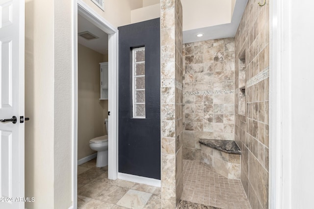 bathroom featuring toilet and tiled shower