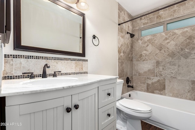 full bathroom with backsplash, vanity, tiled shower / bath combo, hardwood / wood-style flooring, and toilet