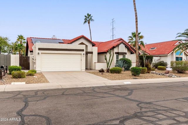 view of front of home with a garage and solar panels