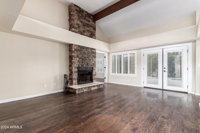 unfurnished living room with a high ceiling, french doors, a stone fireplace, dark hardwood / wood-style floors, and beam ceiling