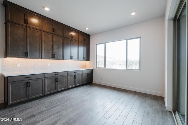 kitchen featuring light hardwood / wood-style flooring, dark brown cabinetry, and backsplash