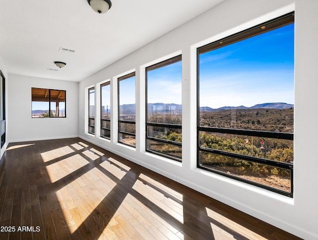 unfurnished sunroom featuring visible vents and a mountain view