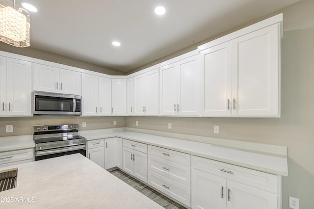 5945 W Lamar Rd, Glendale, AZ 85301 - kitchen featuring appliances with stainless steel finishes, light countertops, recessed lighting, white cabinets, and wood finished floors
