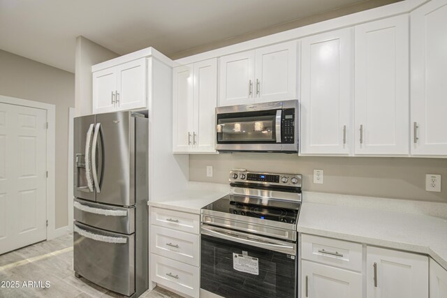 5945 W Lamar Rd, Glendale, AZ 85301 - kitchen featuring appliances with stainless steel finishes, light countertops, white cabinets, and light wood-type flooring