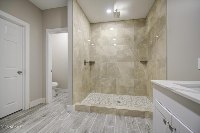 5945 W Lamar Rd, Glendale, AZ 85301 - full bath with toilet, a tile shower, wood tiled floors, vanity, and baseboards