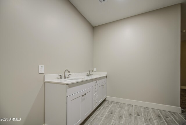 5945 W Lamar Rd, Glendale, AZ 85301 - bathroom featuring baseboards, wood finished floors, and double vanity