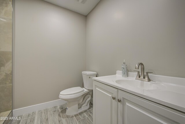 5945 W Lamar Rd, Glendale, AZ 85301 - bathroom with toilet, vanity, wood finished floors, and baseboards