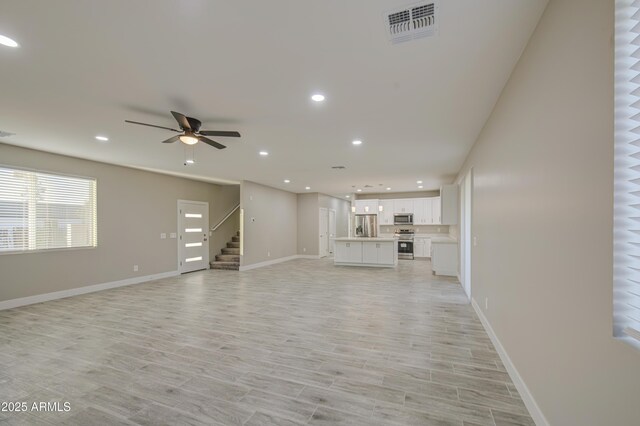 5945 W Lamar Rd, Glendale, AZ 85301 - unfurnished living room featuring recessed lighting, a ceiling fan, stairs, baseboards, and light wood finished floors