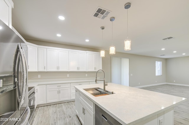 5945 W Lamar Rd, Glendale, AZ 85301 - kitchen featuring appliances with stainless steel finishes, a sink, white cabinets, recessed lighting, and an island with sink