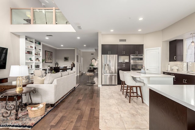 living room with recessed lighting, visible vents, and light wood-style flooring