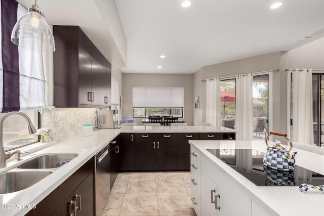 kitchen with backsplash, light countertops, recessed lighting, light tile patterned flooring, and a sink