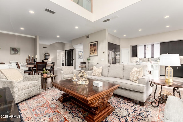 living room featuring light wood-style floors, recessed lighting, and visible vents