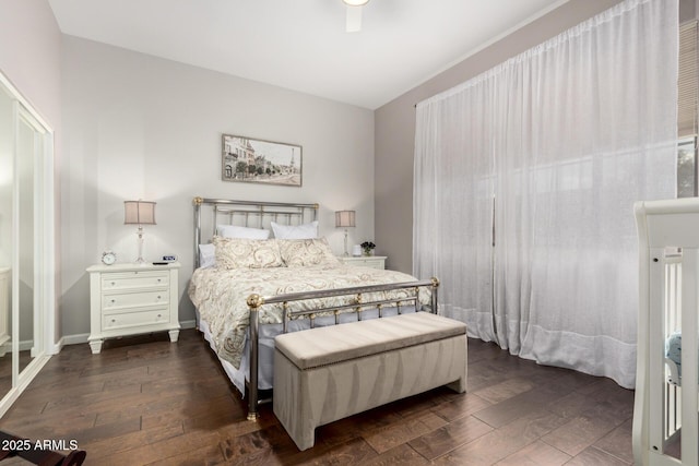 bedroom featuring baseboards and dark wood-style flooring