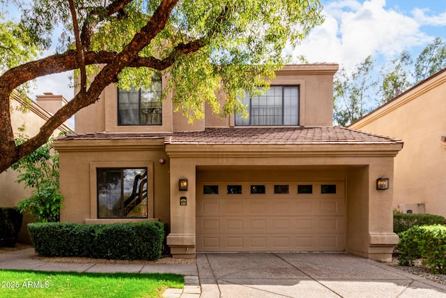 view of front facade featuring stucco siding, driveway, and an attached garage