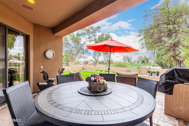 view of patio featuring outdoor dining space, fence, and visible vents