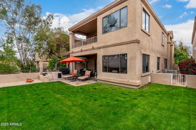 rear view of house featuring a lawn, a patio, a balcony, and fence