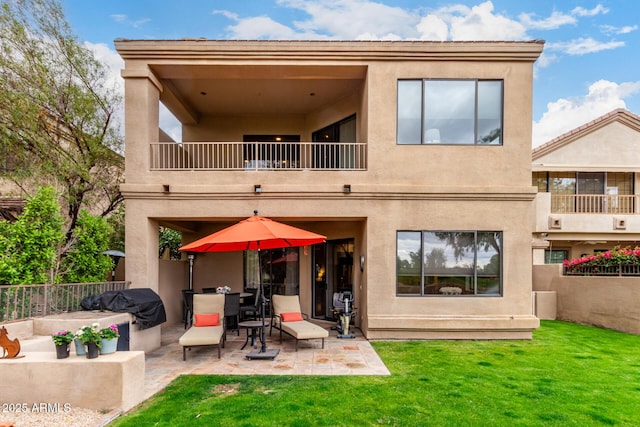 back of property with stucco siding, a patio, a balcony, and fence