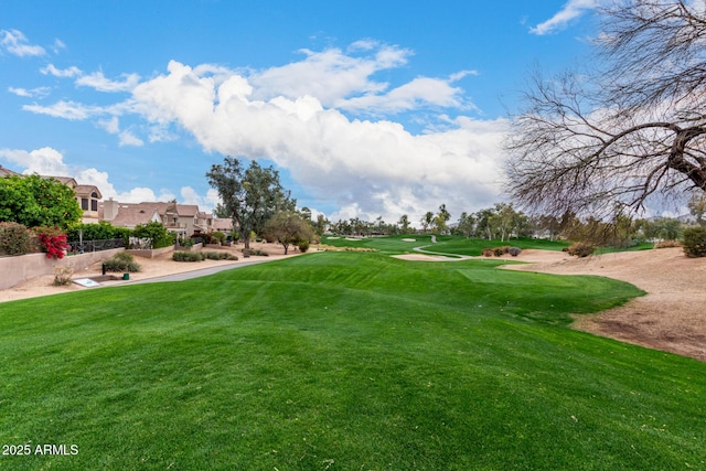 view of property's community featuring a lawn and fence