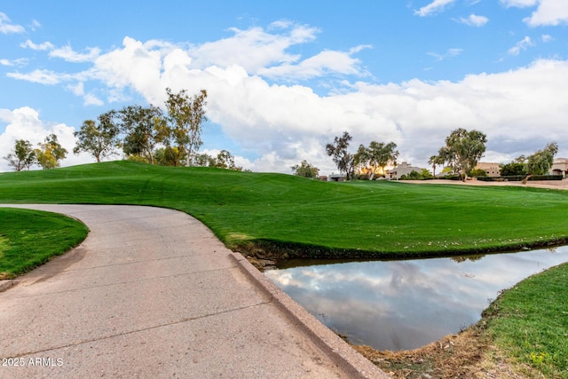 view of community with view of golf course and a lawn