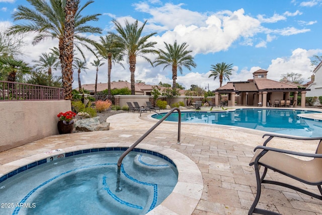 community pool with a community hot tub, a patio area, and fence