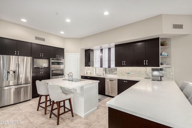 kitchen featuring a kitchen bar, light countertops, visible vents, and appliances with stainless steel finishes