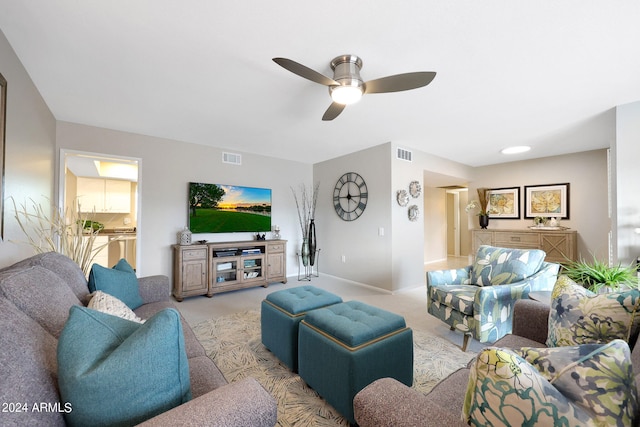 carpeted living room with ceiling fan