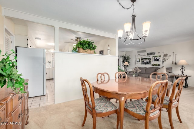 dining room with light colored carpet and ceiling fan with notable chandelier