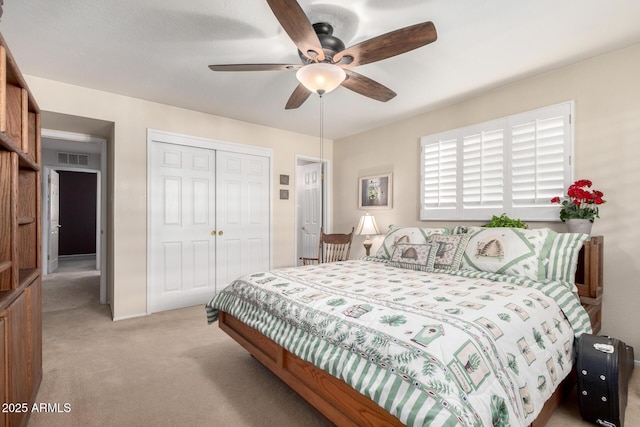 carpeted bedroom featuring ceiling fan and a closet