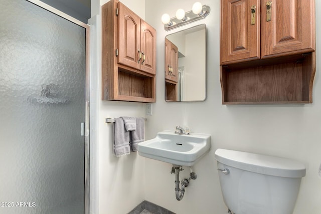 bathroom with a shower with door and toilet