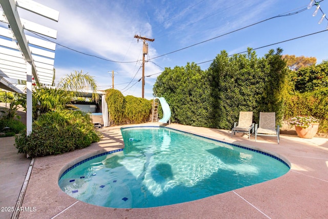 view of swimming pool with a patio and a water slide