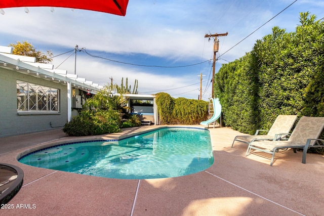 view of swimming pool with a patio area and a water slide