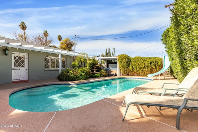 view of pool featuring a patio area and a water slide