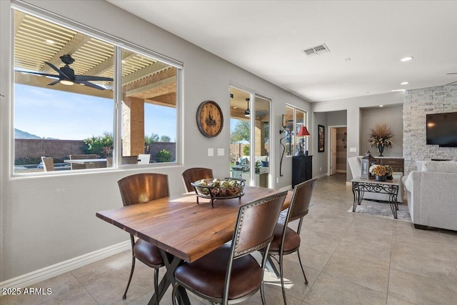 dining room featuring ceiling fan, light tile patterned floors, and a healthy amount of sunlight