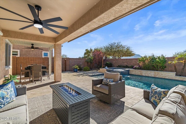 view of patio featuring an outdoor living space with a fire pit, ceiling fan, and an in ground hot tub