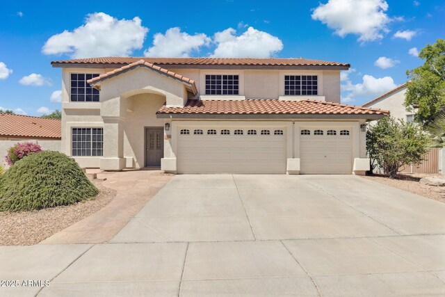 12748 N 57th Dr, Glendale, AZ 85304 - mediterranean / spanish house featuring stucco siding, driveway, a tiled roof, and an attached garage