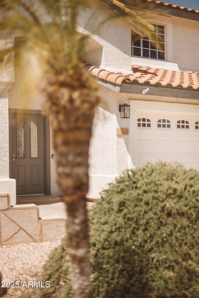 12748 N 57th Dr, Glendale, AZ 85304 - entrance to property with a tiled roof, an attached garage, and stucco siding