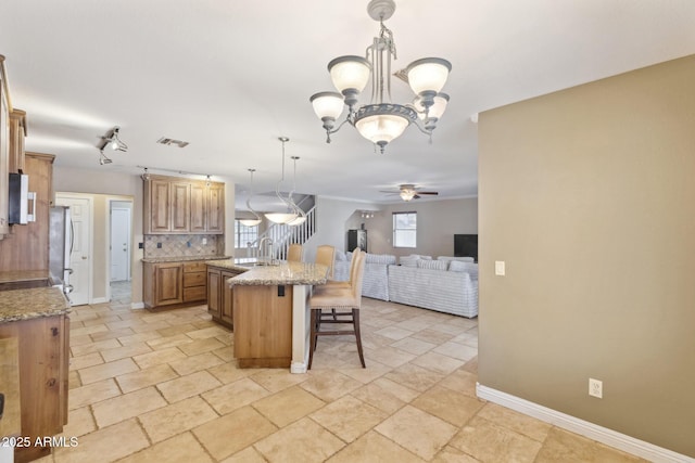 12748 N 57th Dr, Glendale, AZ 85304 - kitchen with a breakfast bar area, open floor plan, ceiling fan, tasteful backsplash, and a chandelier