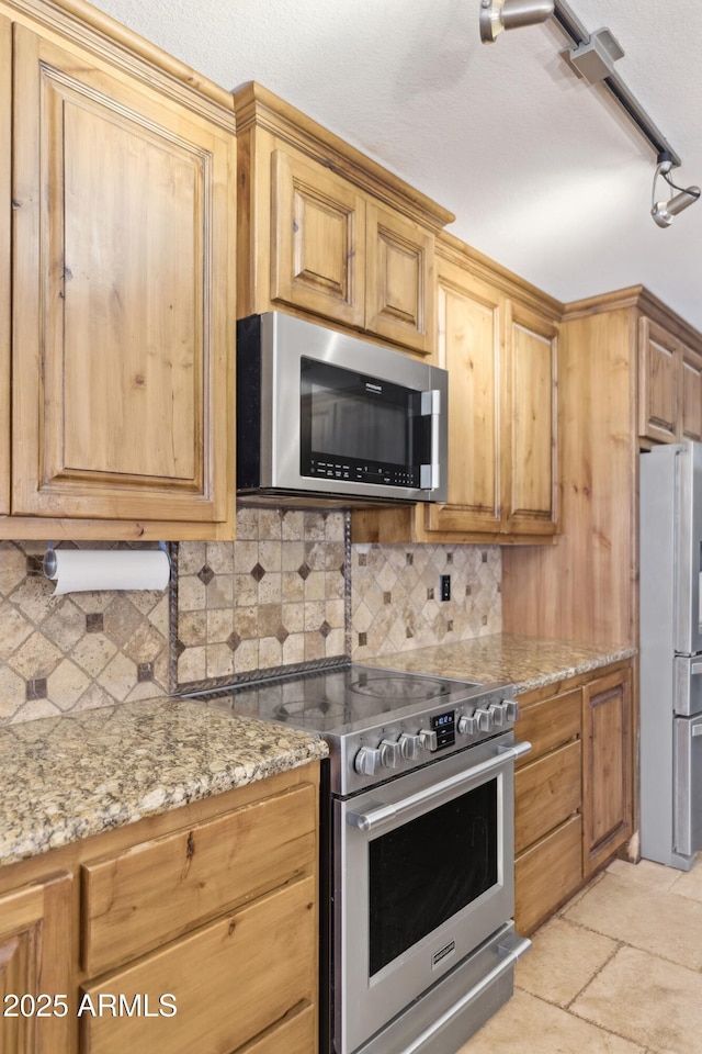 12748 N 57th Dr, Glendale, AZ 85304 - kitchen featuring appliances with stainless steel finishes, backsplash, and light stone countertops