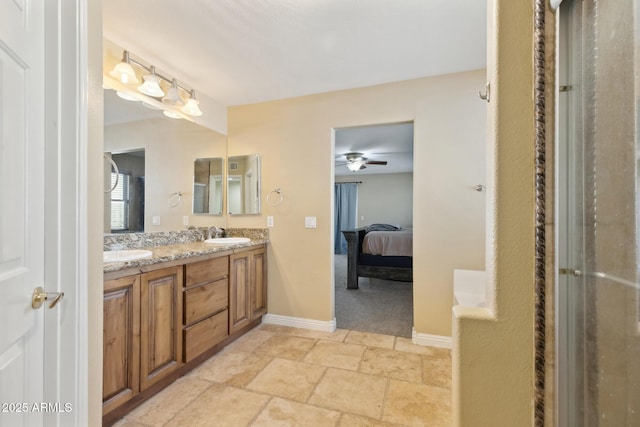 12748 N 57th Dr, Glendale, AZ 85304 - bathroom with ceiling fan, double vanity, ensuite bath, baseboards, and stone finish floors