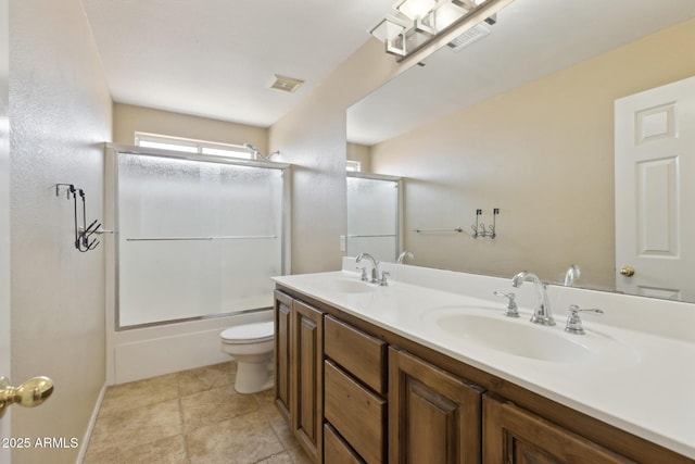 12748 N 57th Dr, Glendale, AZ 85304 - bathroom featuring toilet, double vanity, and bath / shower combo with glass door