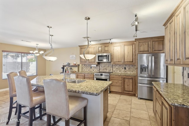 12748 N 57th Dr, Glendale, AZ 85304 - kitchen featuring stainless steel appliances, a sink, tasteful backsplash, a chandelier, and a breakfast bar