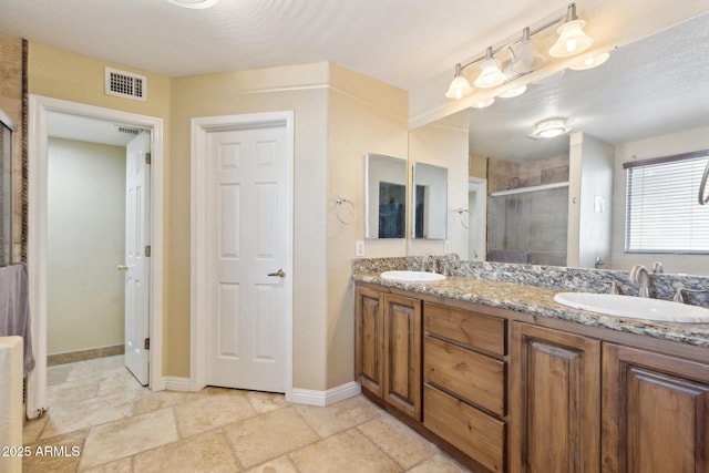 12748 N 57th Dr, Glendale, AZ 85304 - full bath featuring a stall shower, double vanity, baseboards, and stone finish floors